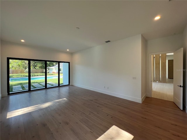 empty room with dark hardwood / wood-style flooring