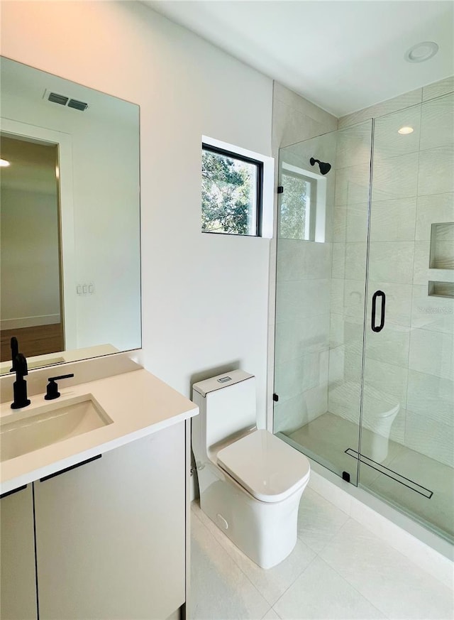 bathroom featuring tile patterned flooring, vanity, a shower with door, and toilet