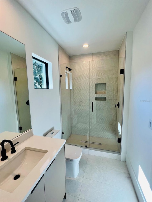 bathroom with tile patterned floors, vanity, toilet, and a shower with door