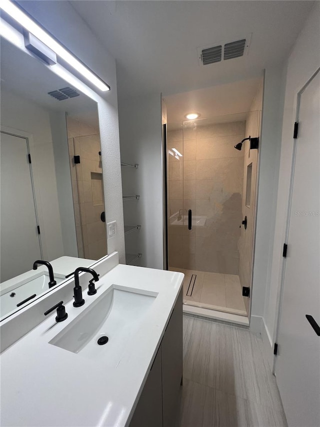 bathroom with vanity and a shower with shower door