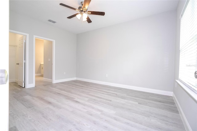 empty room with ceiling fan and light hardwood / wood-style floors