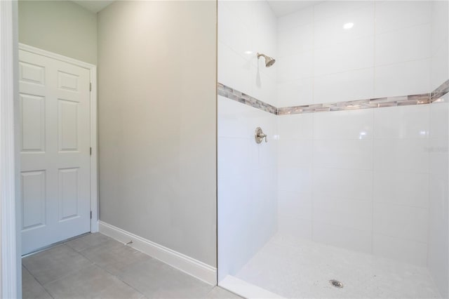 bathroom with tile patterned flooring and a tile shower