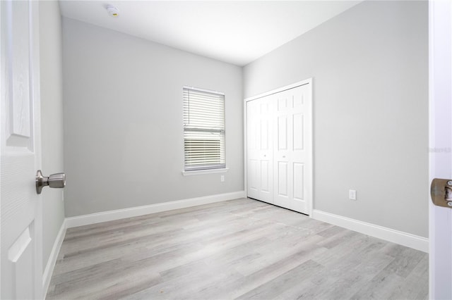 unfurnished bedroom featuring light hardwood / wood-style floors and a closet