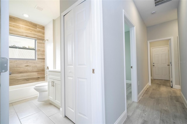 corridor with wood walls and light hardwood / wood-style floors