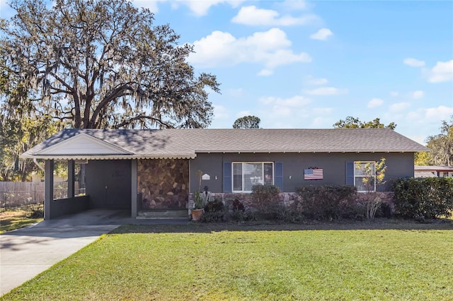 ranch-style home featuring a front lawn and a carport