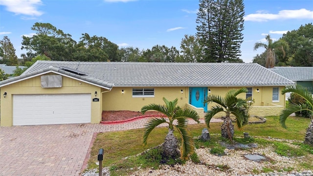 ranch-style home featuring a garage and a front lawn