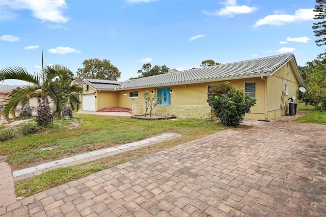 single story home with a front yard and a garage