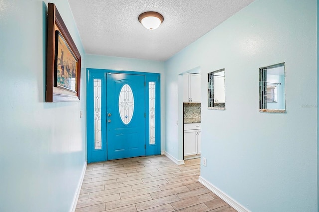 entryway featuring light hardwood / wood-style floors and a textured ceiling