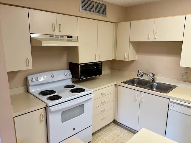 kitchen with white appliances, white cabinetry, and sink