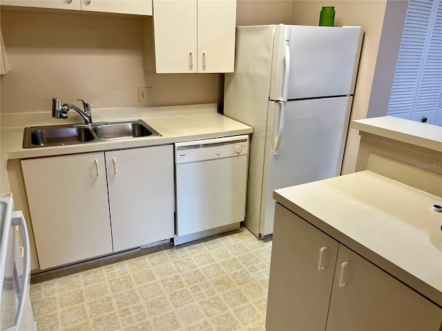 kitchen with white appliances, white cabinetry, and sink