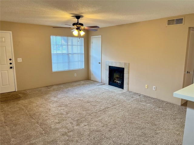 485 Forestway Cir Unit 202, Altamonte Springs, FL 32701 - unfurnished living room with carpet floors, a textured ceiling, a ceiling fan, and a tiled fireplace