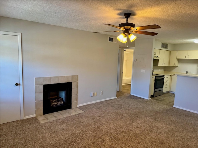 unfurnished living room with carpet floors, a fireplace, and visible vents