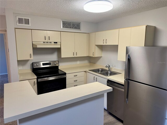 kitchen featuring appliances with stainless steel finishes, a sink, visible vents, and under cabinet range hood