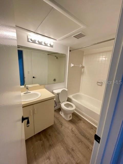 full bathroom featuring hardwood / wood-style floors, vanity, toilet, and bathtub / shower combination