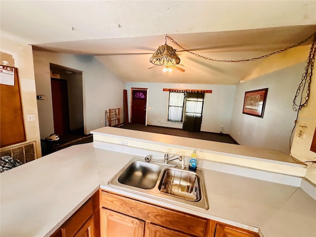 kitchen with kitchen peninsula, lofted ceiling, and sink