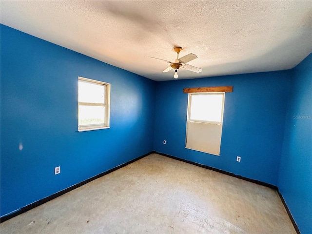 spare room with a ceiling fan, a textured ceiling, baseboards, and carpet flooring