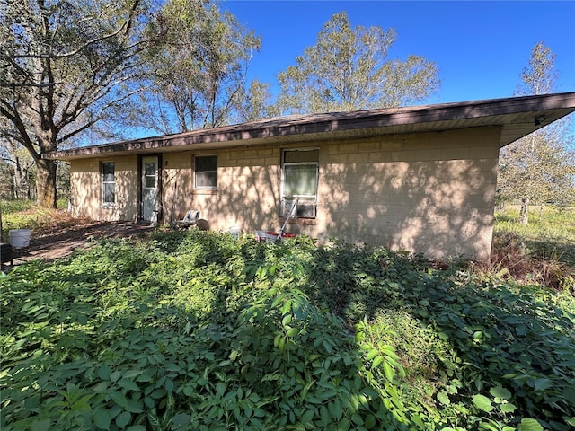 back of property featuring concrete block siding