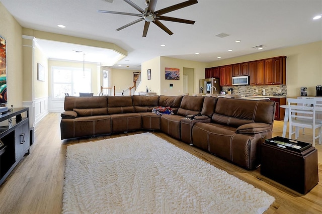 living room with ceiling fan and light hardwood / wood-style floors