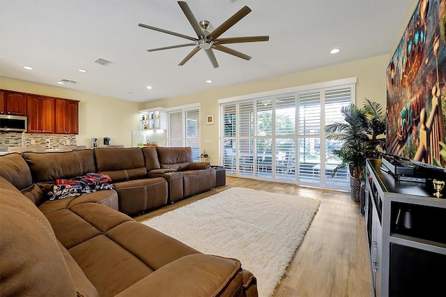 living room with ceiling fan and light wood-type flooring