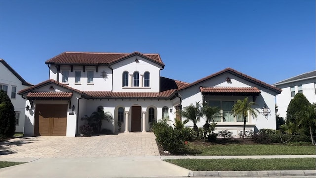 mediterranean / spanish home with a front yard and a garage