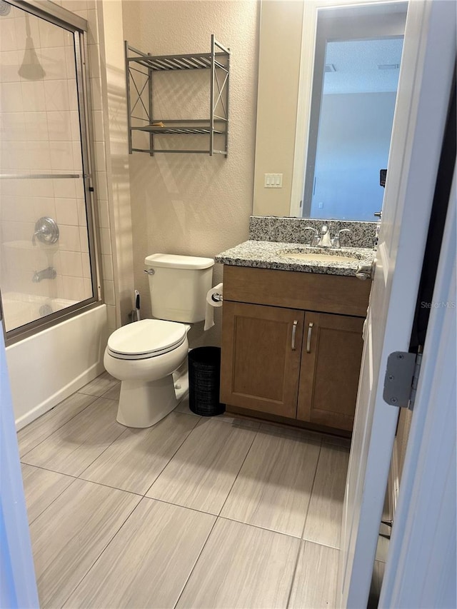 full bathroom featuring vanity, enclosed tub / shower combo, and toilet