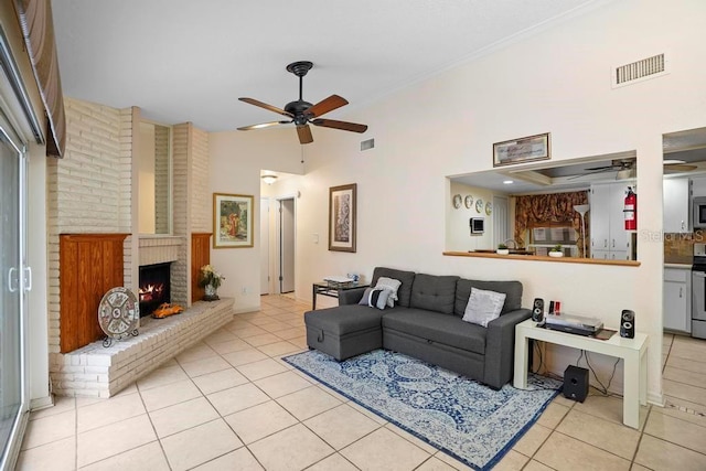 tiled living room featuring ceiling fan, a fireplace, and a high ceiling