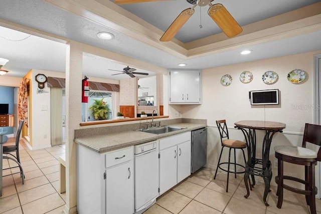 kitchen featuring dishwasher, white cabinetry, sink, and light tile patterned floors