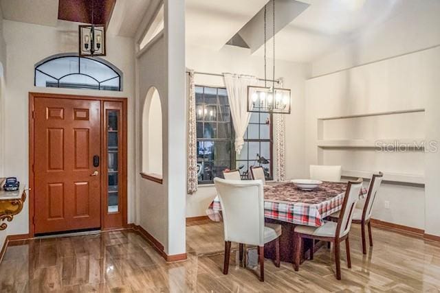 dining area with light hardwood / wood-style flooring and a notable chandelier