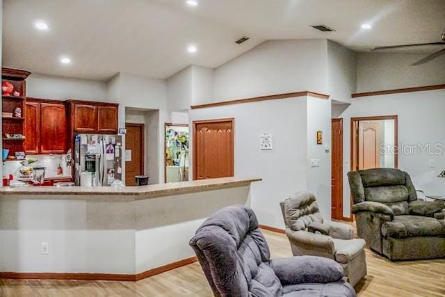 kitchen featuring stainless steel refrigerator with ice dispenser, high vaulted ceiling, ceiling fan, and light wood-type flooring