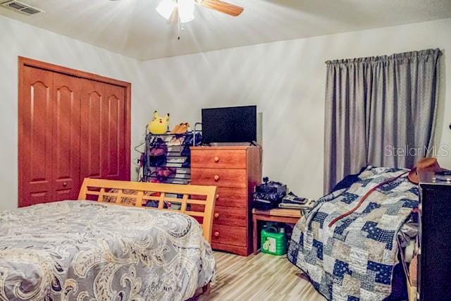 bedroom featuring ceiling fan, a closet, and light hardwood / wood-style flooring