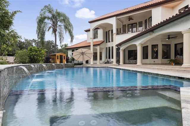 view of swimming pool with pool water feature and ceiling fan