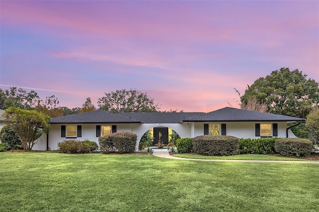 single story home with a lawn