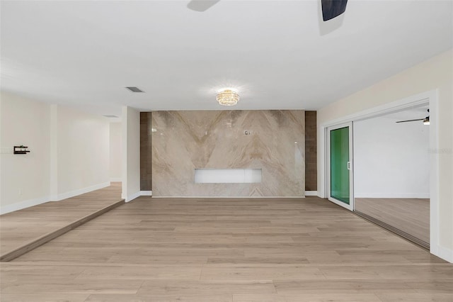 unfurnished room with light wood-type flooring and ceiling fan