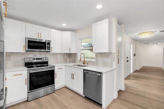 kitchen featuring light hardwood / wood-style floors, sink, white cabinetry, and stainless steel appliances