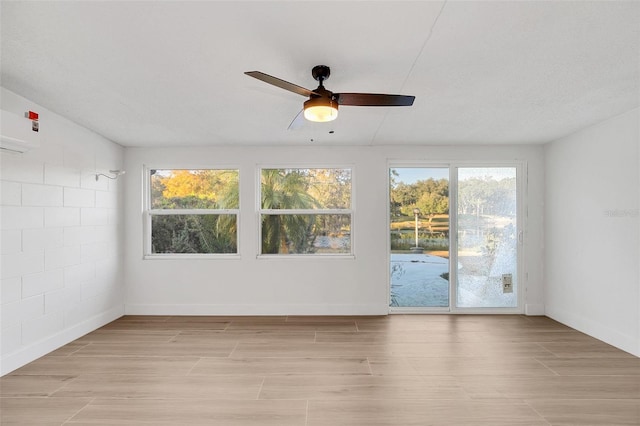 unfurnished sunroom with ceiling fan