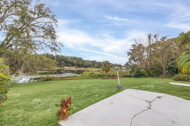 view of yard featuring a water view and a patio