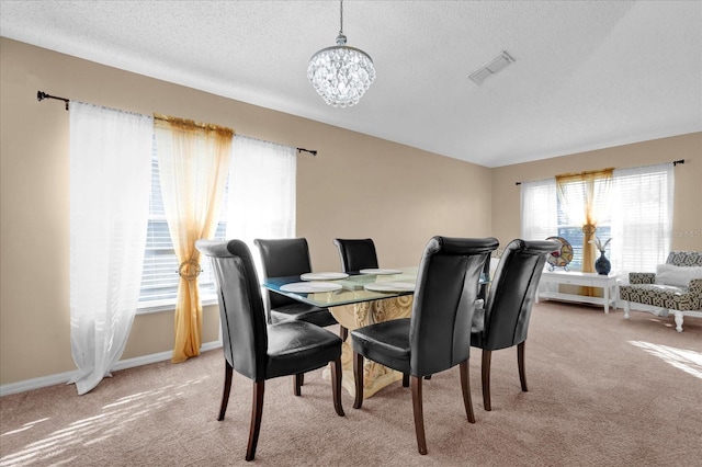 carpeted dining room with a notable chandelier and a textured ceiling