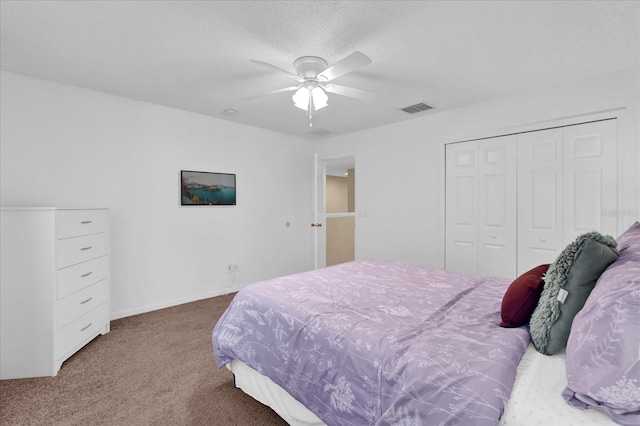 bedroom with a textured ceiling, carpet floors, a closet, and ceiling fan