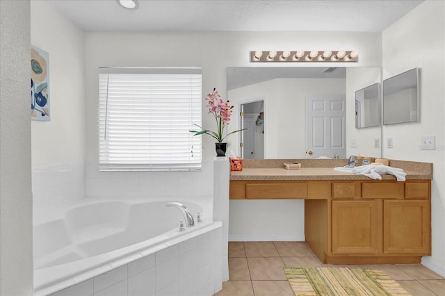 bathroom with tile patterned flooring, vanity, and a relaxing tiled tub