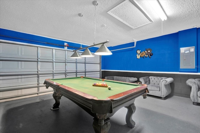 rec room featuring billiards, a textured ceiling, electric panel, and concrete flooring