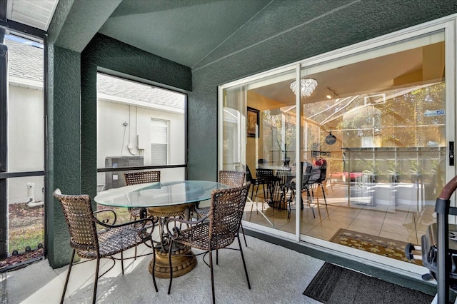 interior space featuring an inviting chandelier, plenty of natural light, and lofted ceiling