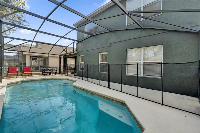 view of swimming pool with a patio area and a lanai