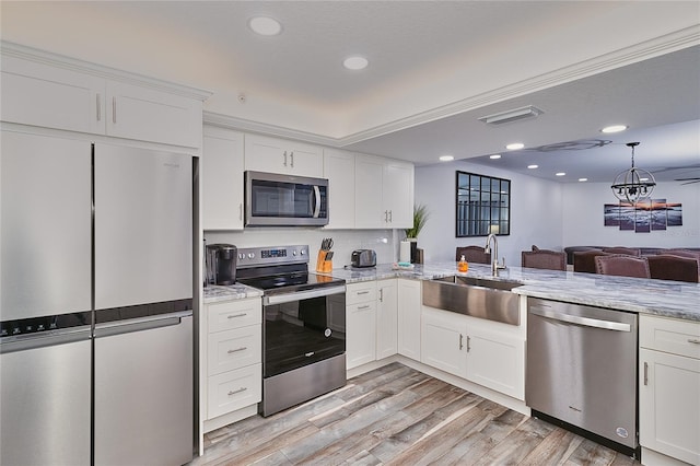 kitchen with sink, stainless steel appliances, light stone counters, light hardwood / wood-style flooring, and white cabinets