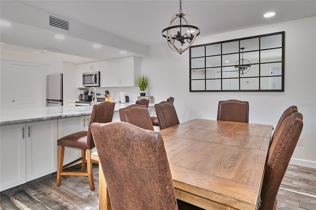 dining space featuring dark hardwood / wood-style floors and an inviting chandelier