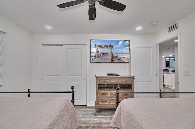 bedroom featuring ceiling fan, wood-type flooring, and a closet