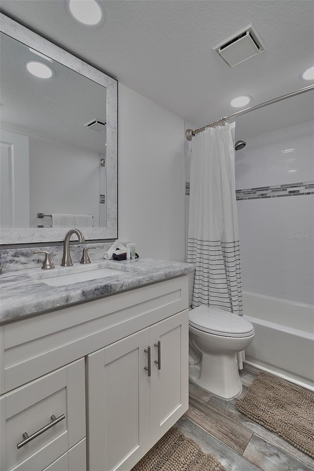 full bathroom featuring hardwood / wood-style flooring, vanity, toilet, and shower / tub combo