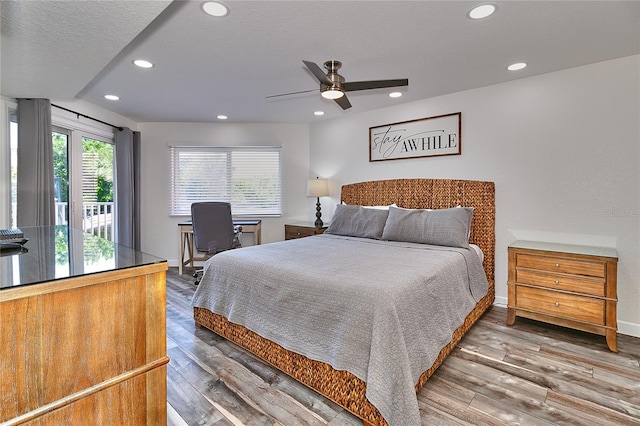 bedroom featuring wood-type flooring, a textured ceiling, multiple windows, and ceiling fan