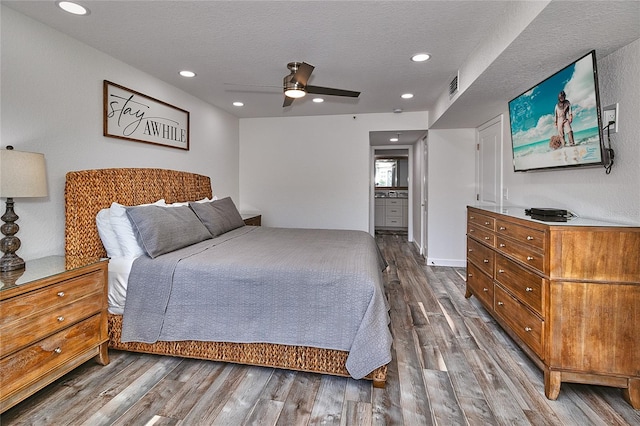 bedroom with hardwood / wood-style floors, ceiling fan, ensuite bathroom, and a textured ceiling