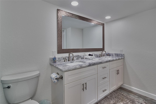 bathroom featuring hardwood / wood-style floors, vanity, and toilet