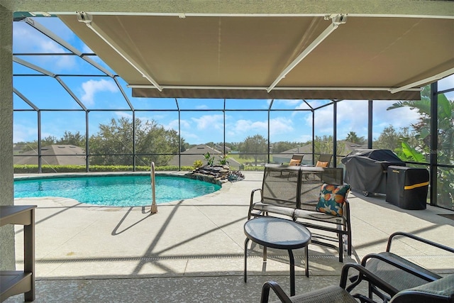 view of pool with area for grilling, a patio area, and glass enclosure